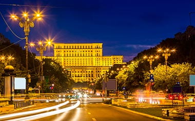 A view down a road in Bucharest at night, towards the Parliament Palace, Romania